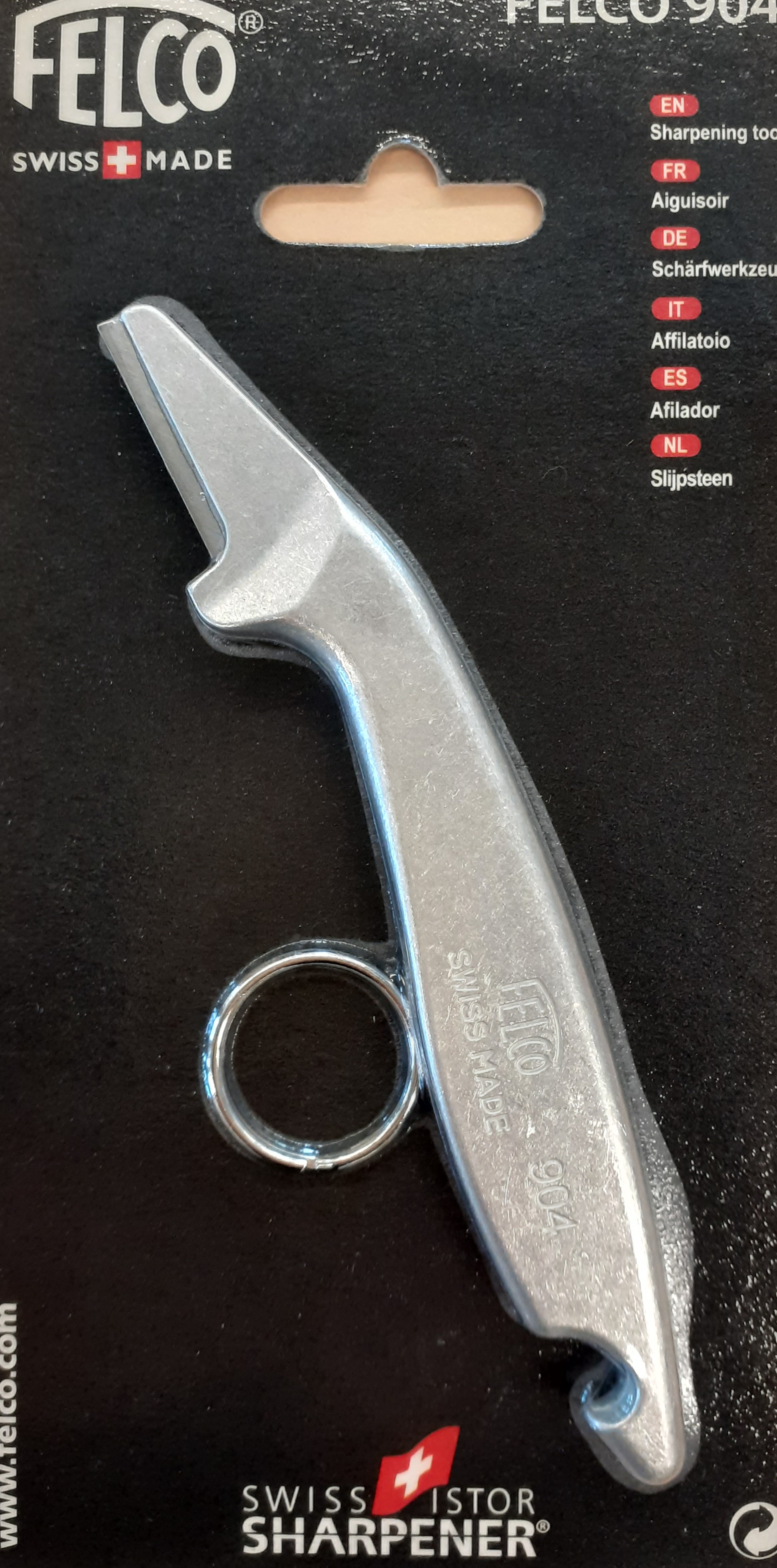 Mustan pahvin päällä metallinen pitkä ja kapea teroitustyökalu.   Mustan pahvin päällä metallinen pitkä ja kapea teroitustyökalu.